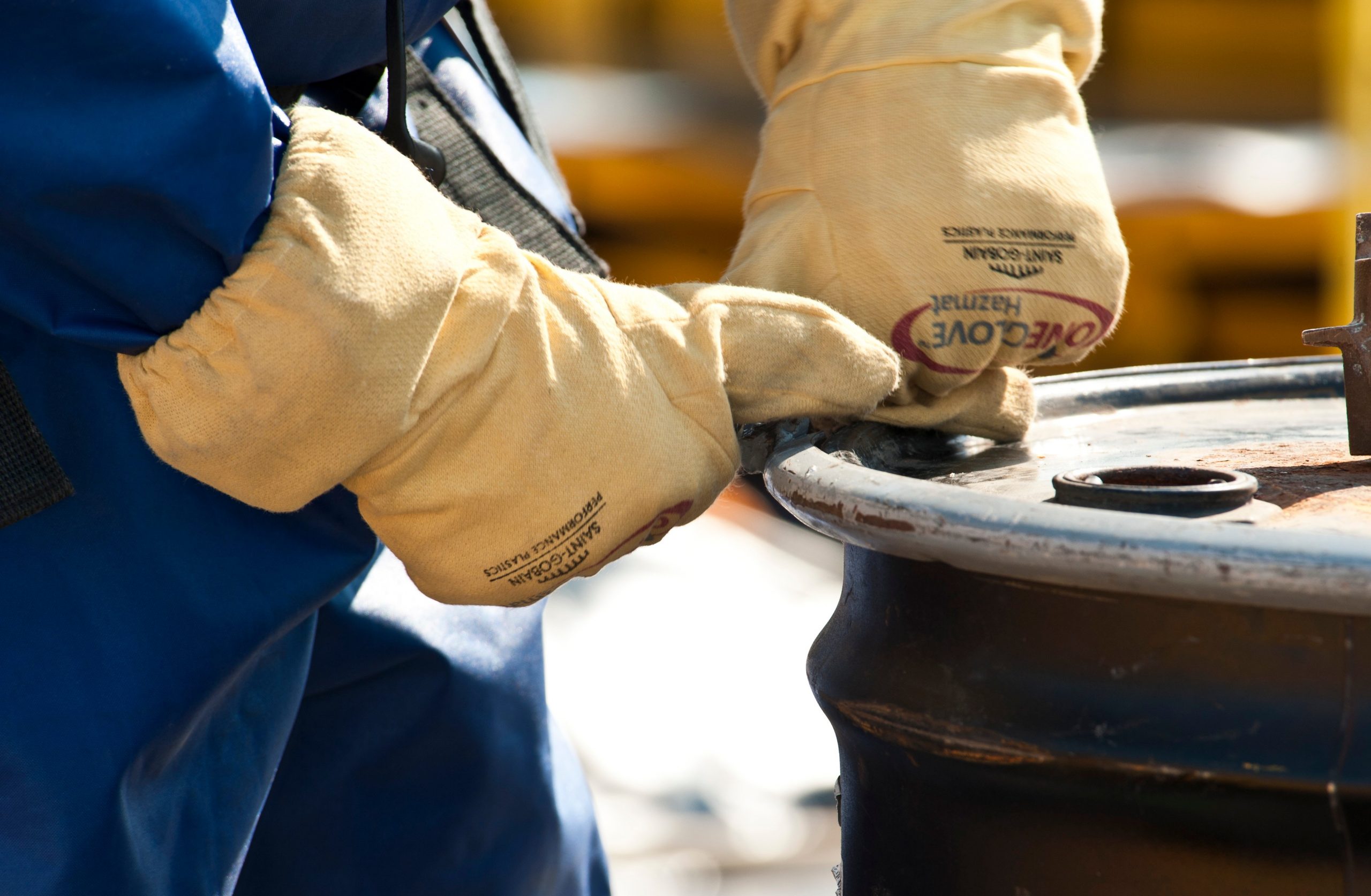 gloved hands sealing barrel top