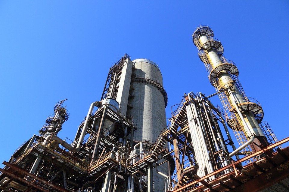 worms eye view of a smoke stack and tank