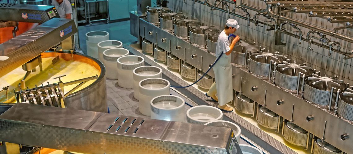 man cleaning vats in a cheese factory with a CIP system