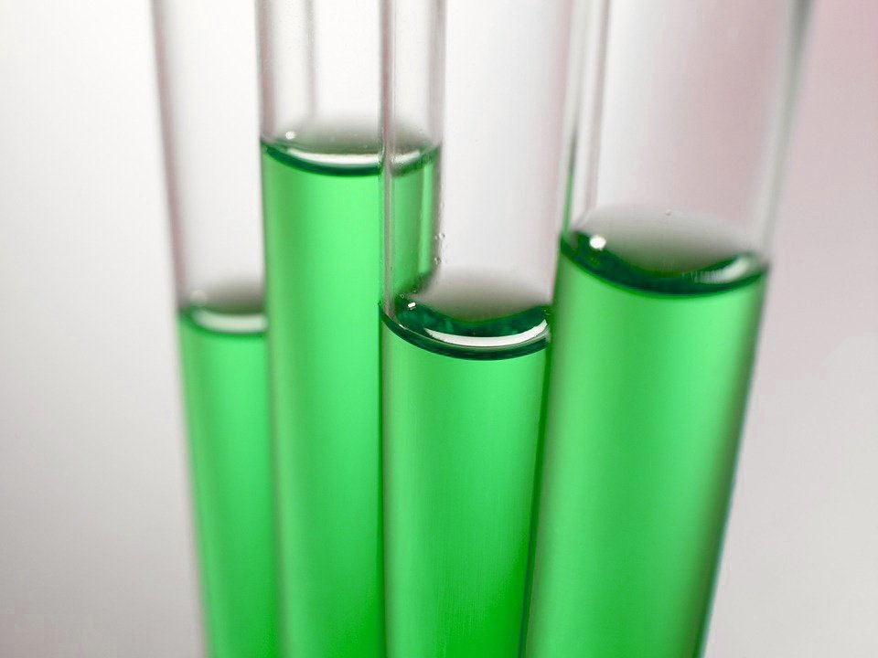 four test tubes with a green chemical in them