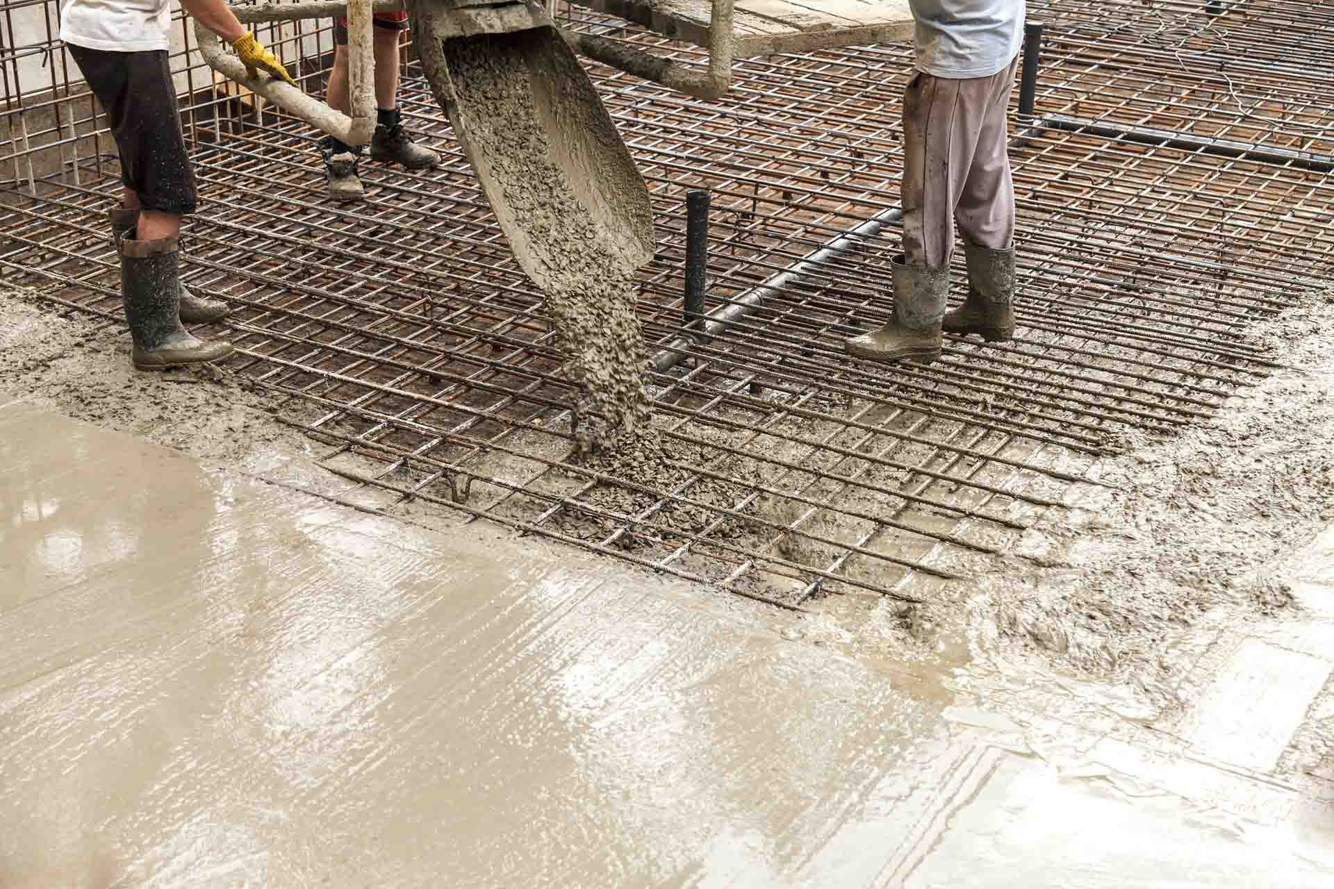 two men pouring concrete into a floor