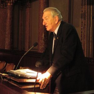 george a olah speaking at a podium