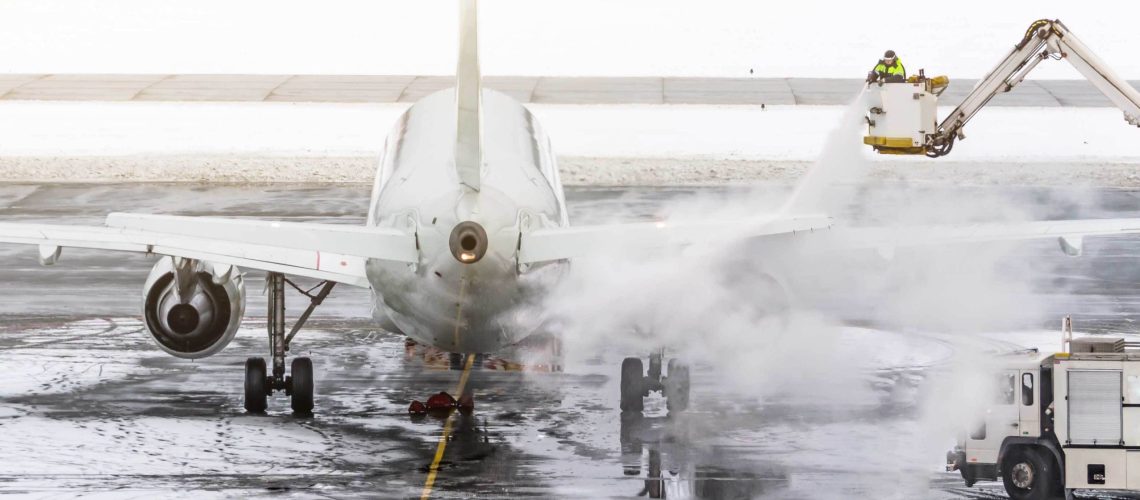 man in a bucket truck deicing a plane using inorganic chemicals